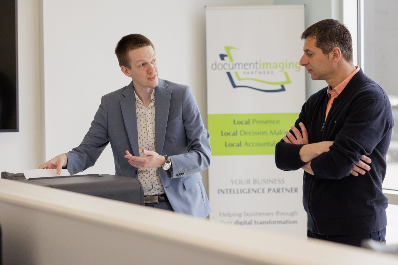 Two service technicians collaborating to troubleshoot a kyocera multifunction printer
